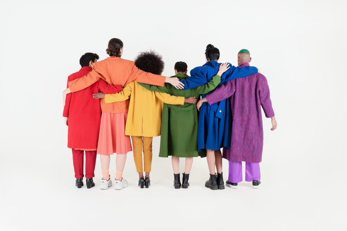Non-Binary Friends in Colorful Outfits on White Background